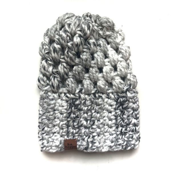 Knitted beanie with a brand label on a white background
