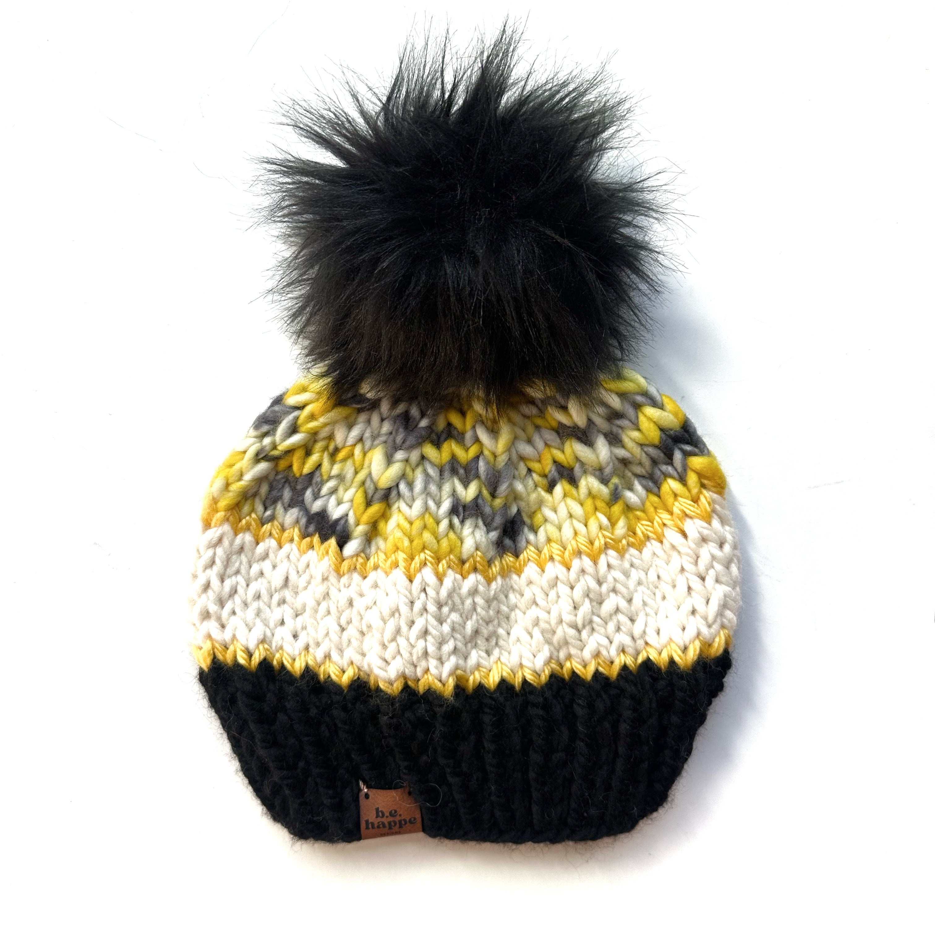 Knitted beanie with a black pom-pom on a white background b.e.happe