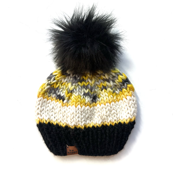 Knitted beanie with a black pom-pom on a white background b.e.happe