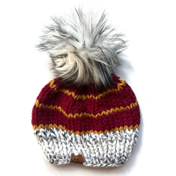 Knitted beanie with striped pattern and pom-pom on a white background b.e.happe