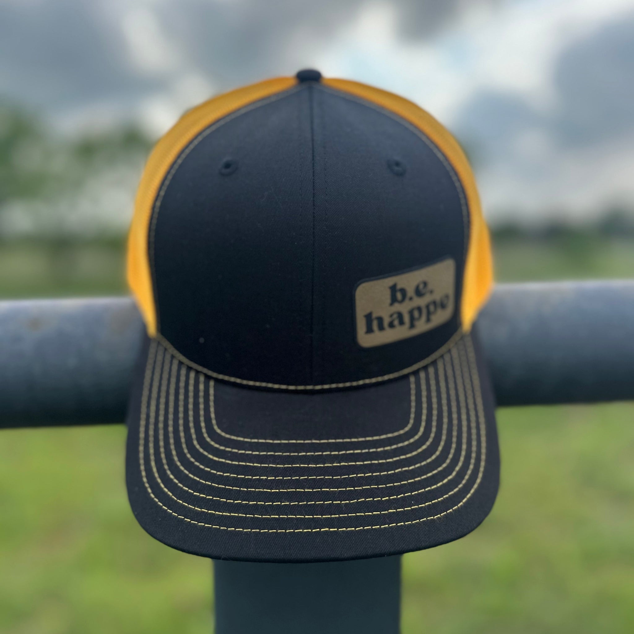 black and yellow trucker cap with behappe branded patch