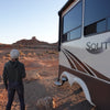 Person standing wearing b.e.happe slouchy beanienext to a Solitude by Grand Design RV in a desert landscape