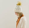 handmade knit beanie with faux fur pom pom; b.e.happe handmade knit winter beanie with mini heart; knit beanie with faux fur pom pom; off white winter hat with pom pom; ecru winter beanie; cream winter beanie with pom pom; handmade knit winter hat with hearts; heart knit hat with pom pom; baby winter hat with pom pom; handmade knit baby hat; coming home outfit; winter toddler hat; toddler baby winter hat