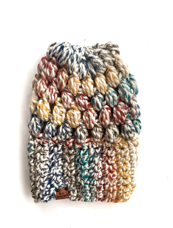 A multicolored crochet slouch hat with a puff stitch pattern, displayed against a white background.